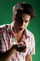 Angry young man yelling at his cell phone