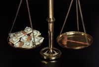Scales with money and a judge's gavel, illustrating bribery, injustice and corruption
