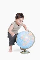 Child with a globe, illustrating that children can learn a lot at a very young age.