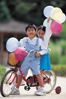 Children on bicycle with training wheels