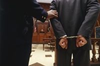 Courtroom photo with defendant in handcuffs.