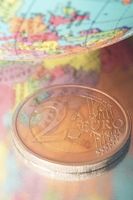 2 euro coin pictured with globe and reflection of Europe