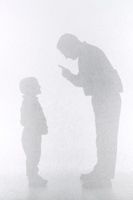 Silhouette of a father verbally correcting his son