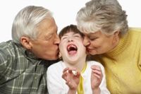 Grandparents kissing laughing granddaughter