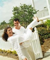 Photo of a husband carrying his wife through the gate