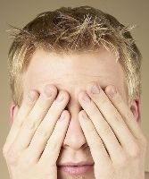 Photo of a man covering his eyes