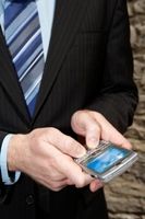 Photo of man in business suit holding a cell phone