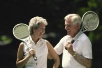 Mature man and woman with tennis rackets, illustrating the benefits of exercise.