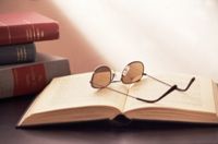 Photo of books and eyeglasses to represent personal Bible study