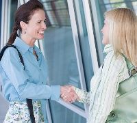 Smiling women meeting and shaking hands