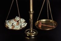 Scales with money and a judge's gavel, illustrating bribery, injustice and corruption