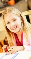 Smiling young girl making a card
