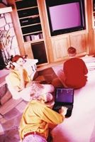 Family using technology: phone, laptop, TV