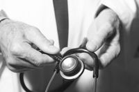 Doctor's hands holding a stethoscope for listening to the heart